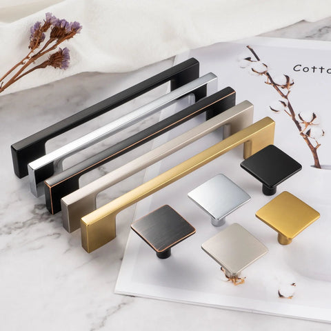 Various colors of cabinet pulls and knobs displayed on a marble surface, including 10 Pack 5 Inch Hole Center Brushed Nickel Cabinet Pulls Satin Nickel Hardware For Cabinets Drawers.