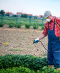 Person using Stainless Steel Garden Sprayer Extension Rod 17.7 Inch Replacement Wand for watering plants in a farm field.