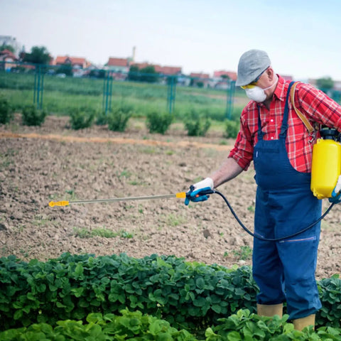 Person using Stainless Steel Garden Sprayer Extension Rod 17.7 Inch Replacement Wand for watering plants in a farm field.