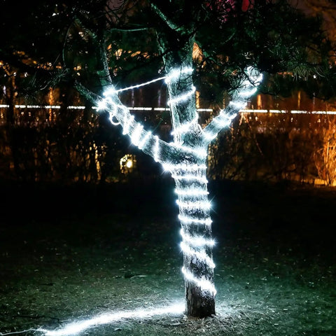 50FT 360 LED Waterproof Rope Lights 110V Connectable Indoor Outdoor White LED Rope Lights For Deck Patio Pool Landscape Lighting With Easy Install Screws And Clamps wrapped around a tree at night