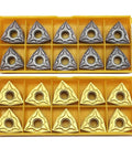 Front view of two yellow trays containing 20 WNMG triangular carbide turning inserts in bronze/gold and gray finishes.