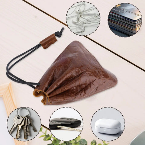 Hardy Cowhide Leather Drawstring Pouch With Vintage Retro Finish Designed For Hauling Your Daily Grind Essentials Travel Toiletries And Quick Pocket Stash on a wooden table.