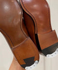 Close-up of installed three pairs metal heel plates for shoes and boots iron sole protectors anti wear pads heel taps tips with screws
