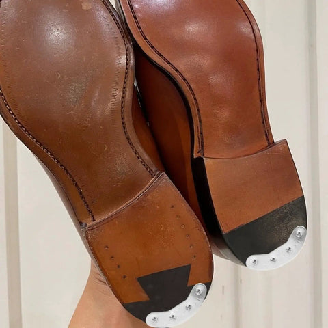 Close-up of installed three pairs metal heel plates for shoes and boots iron sole protectors anti wear pads heel taps tips with screws