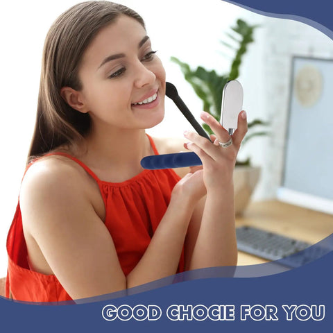 Woman holding a compact mirror in a modern workspace with a plant and desk in the background.