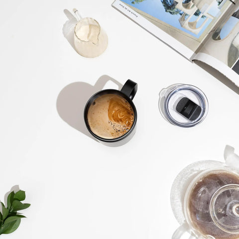 Self Heating Coffee Mug With Rechargeable Battery And Digital Temperature Control Keeps Your Drinks Piping Hot All Day Long Sleek Led Display Makes Temp Swaps A Breeze While The Roomy 16 Oz Black Body Delivers Total Upgrade Vibes For Any Desk Setup. Black 16oz mug with coffee and cream swirls on a white background.