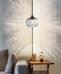 2 Pack 7.7 Inch Black Brownish Grey Seeded Glass Pendant Lights with black finish over a modern side table in a cozy room.