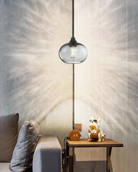 2 Pack 7.7 Inch Black Brownish Grey Seeded Glass Pendant Lights with black finish over a modern side table in a cozy room.