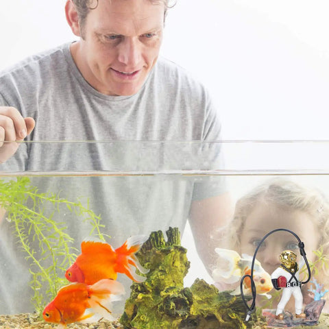 Man and child observing fish tank with Scuba Diver Fish Tank Decoration Vibe Resin Bubbler Ornament and goldfish