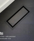Framed Floor Vent Luxe Minimalist Steel HVAC Air Return Register Cover With Adjustable Damper in matte black on hardwood floor.