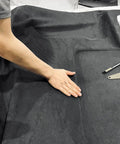 Auto headliner fabric suede with foam backing, black, 120 by 60 inches, laid flat with cutting tools