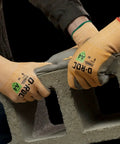 Two hands wearing DX Technology Cut Resistant Work Glove With Polyurethane Palm ANSI A4 Protection Size 9 gripping concrete block.