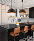 Vintage Black Pendant Light Dome Fixture With Retro Farmhouse Vibe in modern kitchen over black marble island and leather stools.