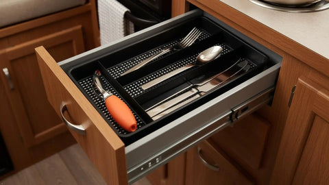 Swanky Four Compartment Utensil And Cutlery Drawer Organizer Tray In Matte Black For Kitchens Or Junk Drawers With Drainage Mesh Bottom keeps utensils neatly organized in a wooden drawer.
