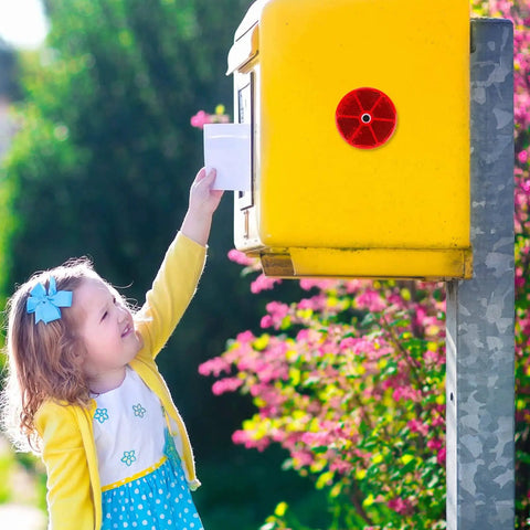Child reaching for a mailbox with a red round reflector attached, highlighting 16 Pack Red Round Reflectors For Driveways Fences Gates