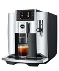 Fully Automatic Chrome Espresso Machine One Touch Custom Barista Brewer Fresh Bean Grinder Premium Coffee Maker Top Shelf Brewmaster with espresso in glass.