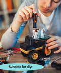 Person assembling a toy vehicle using a screwdriver, surrounded by mechanical parts and tools, suitable for DIY projects.
