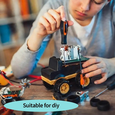 Person assembling a toy vehicle using a screwdriver, surrounded by mechanical parts and tools, suitable for DIY projects.