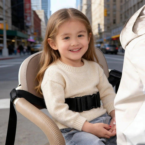 Child sitting in seat with Two-Stage Child Safety Harness For Bikes Trikes And Motorcycles Adjustable Safety Belt in an urban area