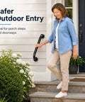 Rock Solid 12 Inch Matte Black Stair Handrail Wall Mounted Grip Aid For Indoor Outdoor Steps Porch Straight Up Safety Rail with a woman using it on porch steps.