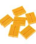 Plug And Play Solderless Breadboard Kit With Six Compact Yellow Protoboard Panels for easy circuit assembly.