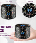 Black Manual Spice Grinder For Kitchen Use with butterfly and moon design, shown on hand for size reference
