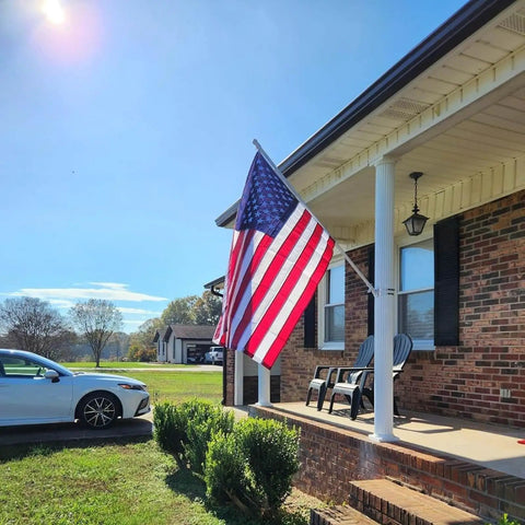 Tough As Nails 3x5 Ft US Flag For High Winds 420D Polyester with brass grommets on porch, sunlit day, ideal for weather resistant display.