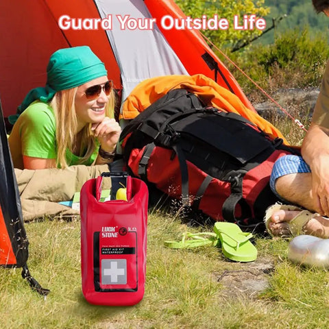 Must Have Waterproof Emergency Kit For Boating And Outdoor Adventures in red bag at campsite with tent and backpacks.