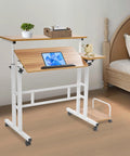 Effortless Folding Standing Desk With Smooth Rolling Casters And Tilted Writing Panels For Total Flex Work From Home Setup Featuring Quick Height Adjustments In Modern Light Walnut And White, shown in a bedroom setting.
