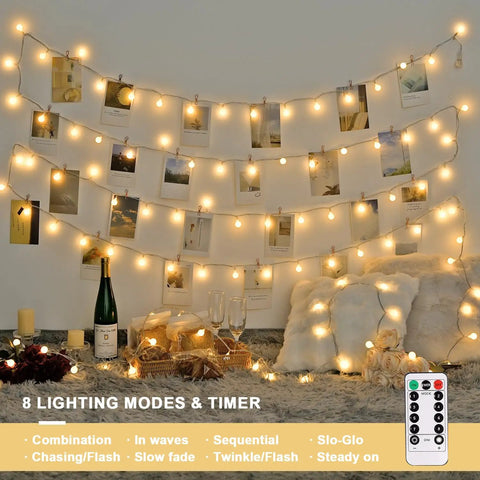 Warm White 100 LED Globe Battery Operated Christmas Lights Indoor With Eight Modes For Cozy Dorm Room Bedroom Or Tree Decor Soft Glow Easy On Battery Perfect For Year Round Holiday Vibes, decorating a wall with photos and pillows below.