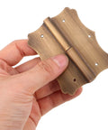 Hand holding Copper Heavy Duty Window And Door Hinge With Vintage Decorative Edges Built To Last Rust Resistant And Ultra Durable