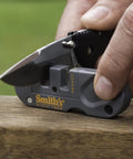 Person sharpening a knife with Dual Stage Knife Sharpener With Preset Carbide And Ceramic Slots Plus Retractable Diamond Rod.