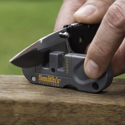 Person sharpening a knife with Dual Stage Knife Sharpener With Preset Carbide And Ceramic Slots Plus Retractable Diamond Rod.