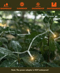 300 LED Curtain String Lights With 8 Modes Plug In Fairy Lights For Bedroom Wedding Party Birthday Indoor Outdoor Backdrop Decoration Warm White For Indoor Outdoor Living Spaces shown outdoors on wet leaves