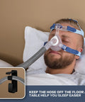Man using CPAP machine with Double Hook CPAP Hose Holder And Mask Hanger For Bed Mounts With Anti Skid Base, hose elevated for comfort.