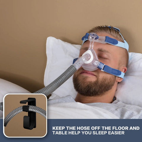 Man using CPAP machine with Double Hook CPAP Hose Holder And Mask Hanger For Bed Mounts With Anti Skid Base, hose elevated for comfort.