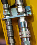 Close-up of CEKER 1/4 in NPT hydraulic quick-disconnect couplings (flat-face) on yellow skid-steer equipment