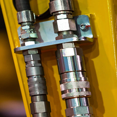 Close-up of CEKER 1/4 in NPT hydraulic quick-disconnect couplings (flat-face) on yellow skid-steer equipment