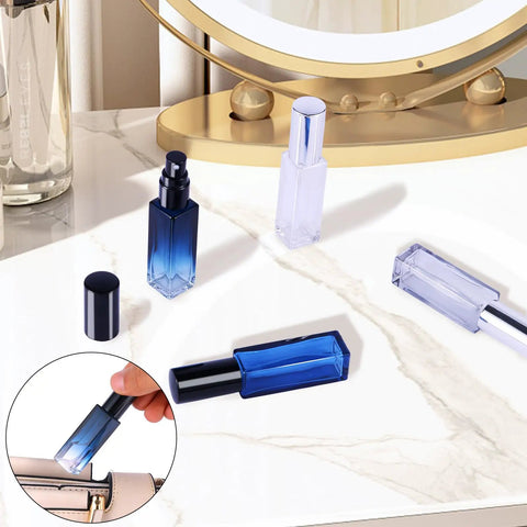 Four Glass Perfume Spray Bottles Set Refillable Travel Size Atomizers with fine mist on marble surface, includes funnel and pipette.