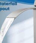 Close-up of tall vessel sink faucet with waterfall flow spout, single handle mixer tap in brushed nickel for bathroom vanity.
