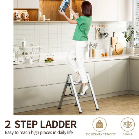 Two Step Folding Ladder With Anti Slip Wide Pedals in use by person reaching high shelf in kitchen, lightweight aluminum build