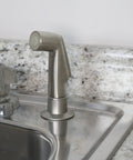 Brushed Nickel Kitchen Sink Side Spray Head 1 Pack With Easy On Off Thumb Control installed next to a faucet on a countertop