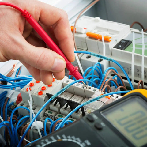 Hand testing circuit board wires with multimeter for electrical diagnostics