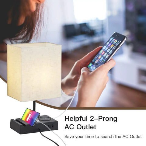 Two Pack Bedside Lamps With Wireless Charging, USB A And USB C Ports, And AC Outlet next to a phone charging