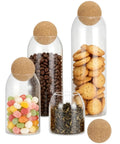 Straight Up Kitchen Essential Four Piece Glass Jar Collection With Airtight Spherical Cork Lids, filled with tea, candy, cookies, and coffee.