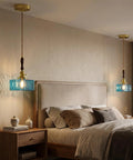 BBLLWJ 1-Pack Vintage Pendant Light for Kitchen Island, Brass & Wood Hanging Fixture with 78" Adjustable Cord, Blue Rectangular Hammered Glass Ceiling Light for Dining Room, Sink, Bedroom above a bed in a cozy bedroom setting.