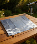 Silver 420D Oxford Telescope Cover For Outdoor Use With Reflective Heat Defense on wooden table, telescope in background.
