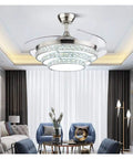 42 Inch Retractable Blade Ceiling Fan Featuring Glowing Crystal Chandelier And Smart Remote Controls For Tunable LED Lights In A stylish living room.