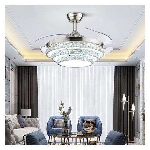 42 Inch Retractable Blade Ceiling Fan Featuring Glowing Crystal Chandelier And Smart Remote Controls For Tunable LED Lights In A stylish living room.
