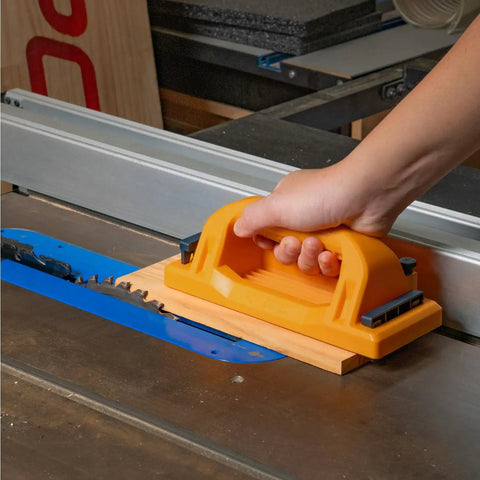 User using Grab Push Block with Retractable Holder and Offset Handle for Easy Material Control on a table saw.